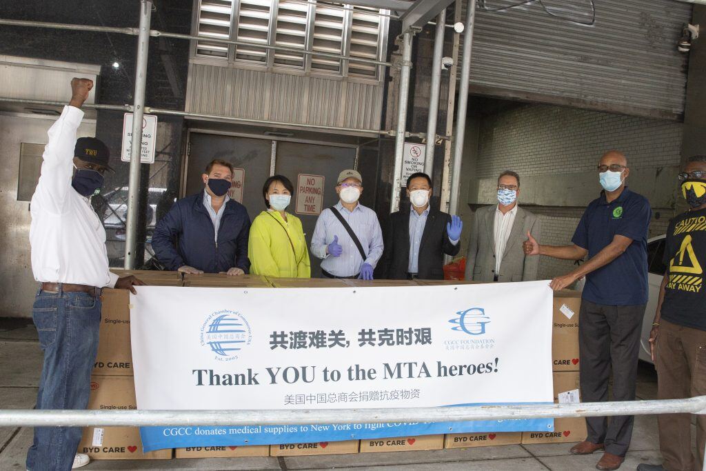 A group of people standing in front of a building</p>
<p>Description automatically generated