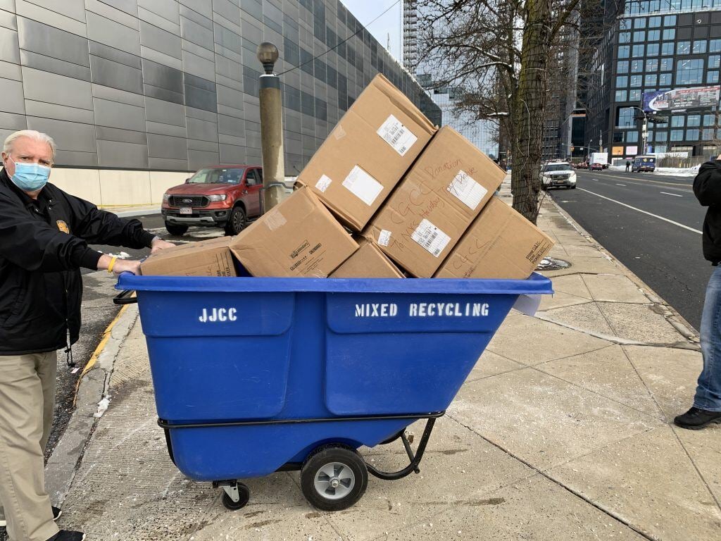 A person pushing a cart full of boxes on the sidewalk</p>
<p>Description automatically generated with medium confidence